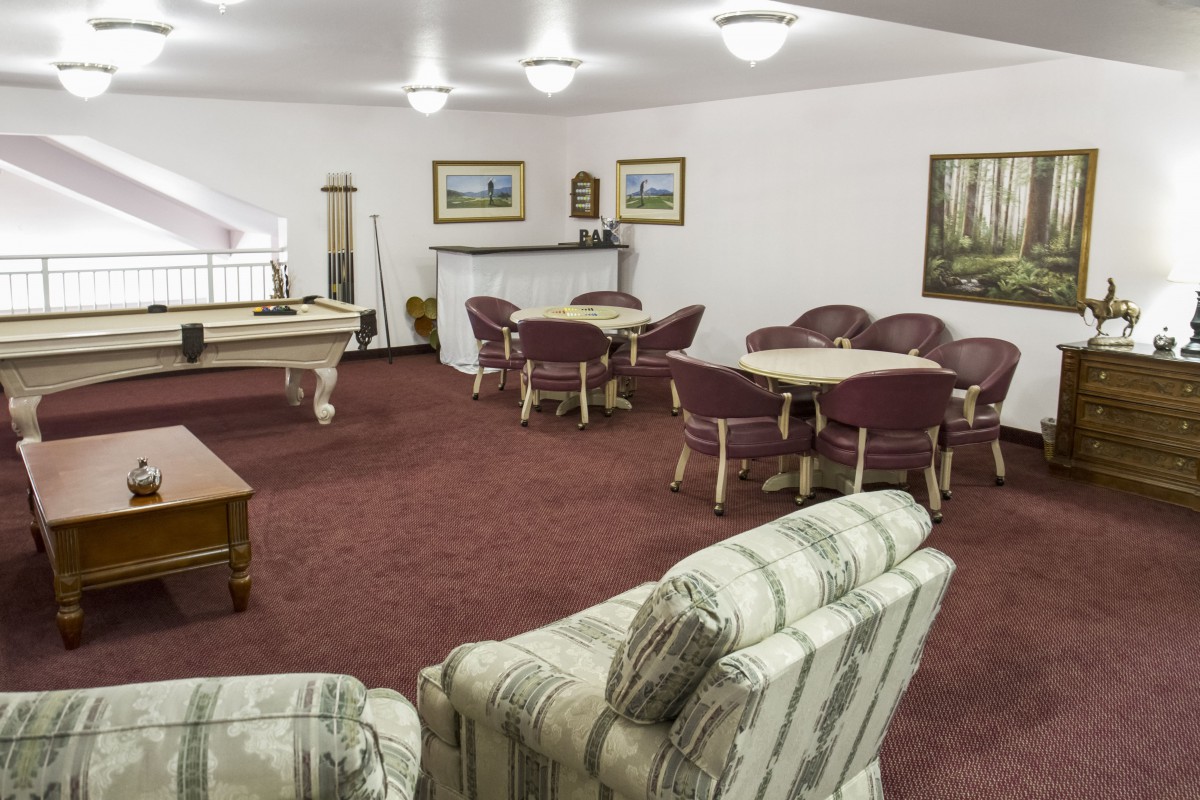 A cozy game room with a billiards table and ample seating.