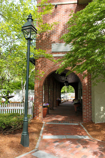A charming brick archway leading to a scenic pathway, framed by lush greenery.