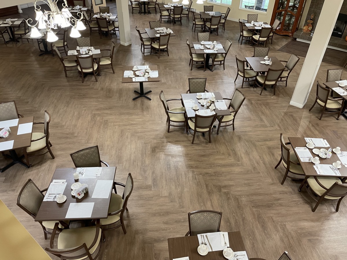 An empty restaurant dining area with neatly arranged tables and chairs.
