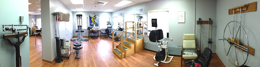 A physical therapy clinic featuring exercise equipment and a staircase for rehabilitation exercises.