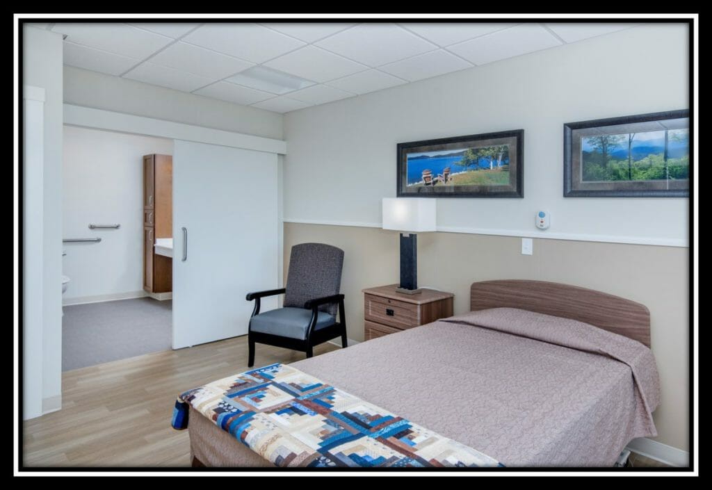 A neatly arranged bedroom with a single bed, artwork on the wall, and essential furniture.