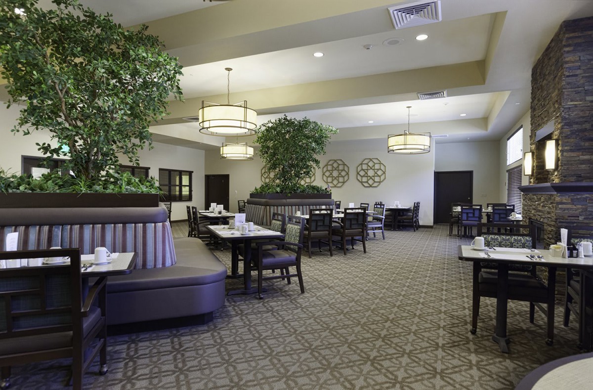 A spacious and elegantly decorated restaurant interior with arranged tables and chairs.