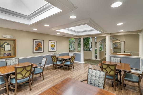 A well-lit dining area featuring tables, chairs, and decorative artwork on the walls.