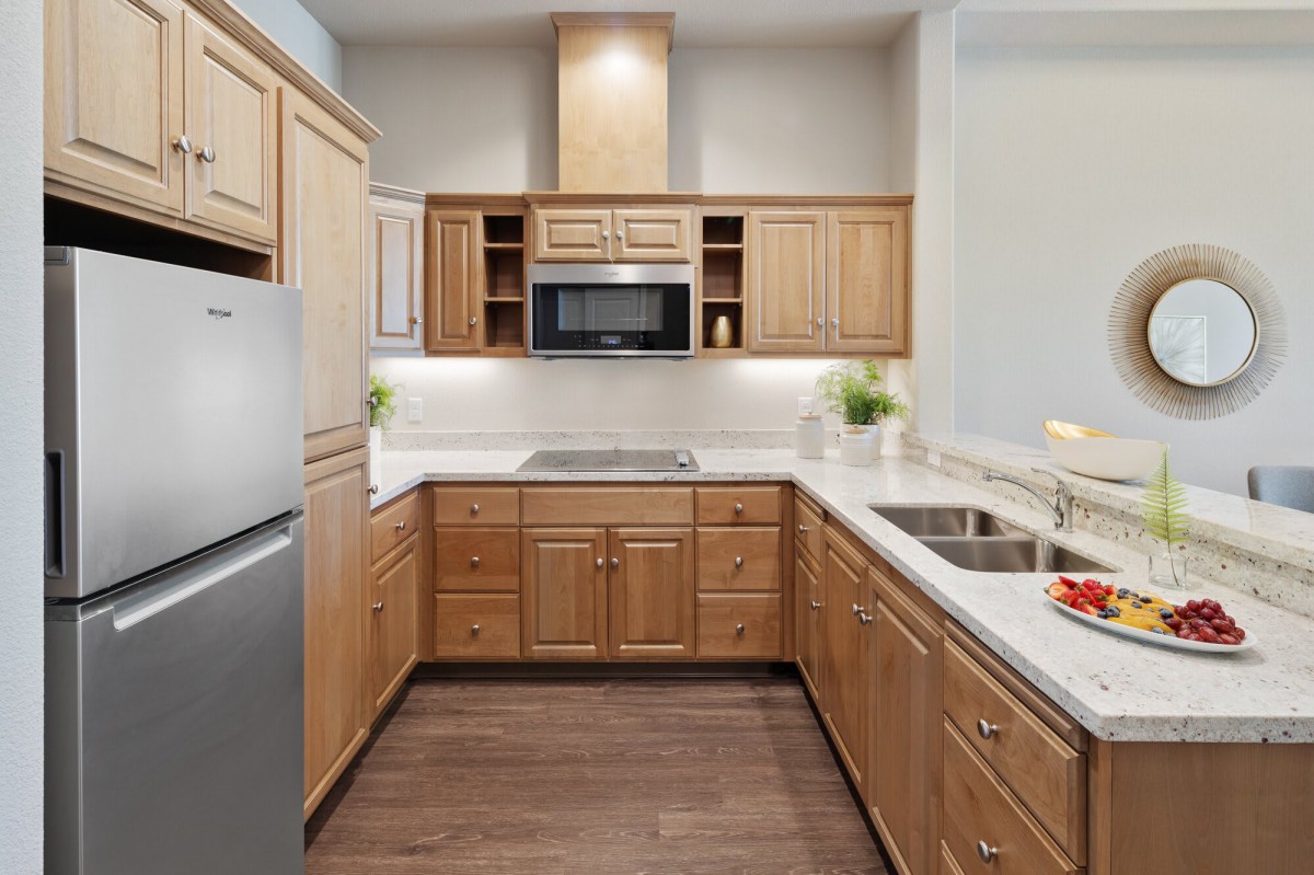 A modern kitchen with wooden cabinets and stainless steel appliances.