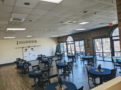 A spacious dining area with blue tables and large windows, creating a bright and inviting atmosphere.