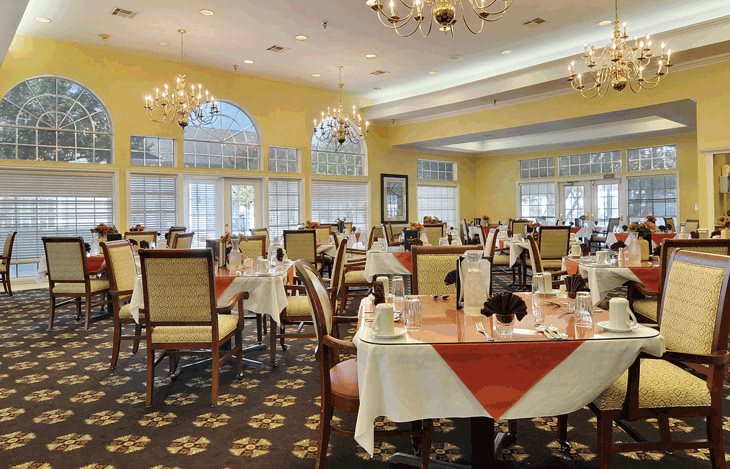 Elegant dining area with arranged tables and chandeliers.