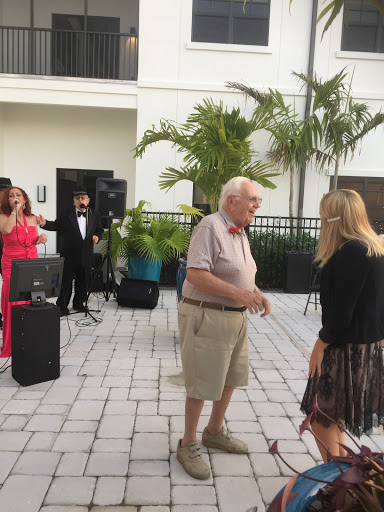 A lively outdoor party where guests are enjoying music and dancing.