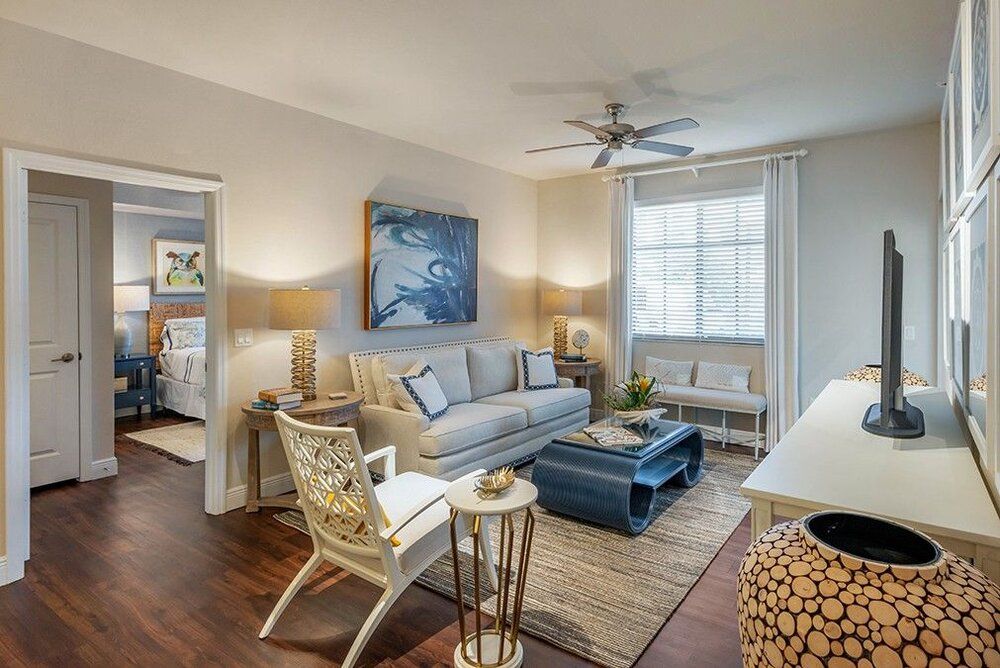 A cozy and stylish living room featuring a comfortable sofa, chic artwork, and abundant natural light.