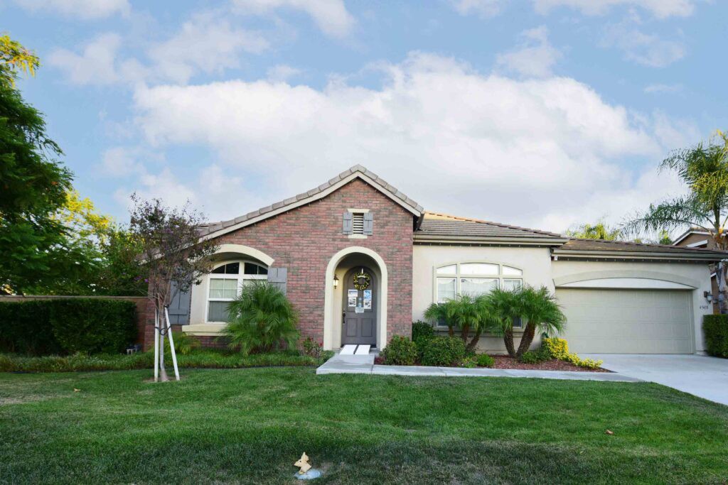 A single-story suburban house with a brick facade and well-maintained front yard.
