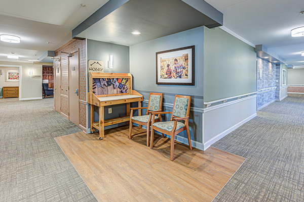 A cozy hallway corner with chairs and decorative artwork on the wall.