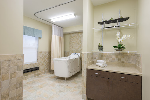 A well-lit and modern patient room in a hospital, featuring a comfortable bed and calming decor.