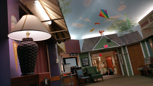A cozy indoor space featuring a whimsical ceiling design with kites and a comfortable seating area.
