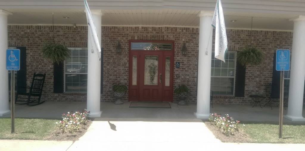 A welcoming front entrance with a red door, brick walls, and white columns.
