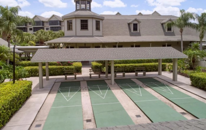An outdoor game court in front of a multi-story building with unique architectural features.