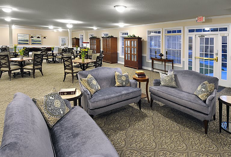 Spacious living room with comfortable sofas, a dining area, and elegant lighting.