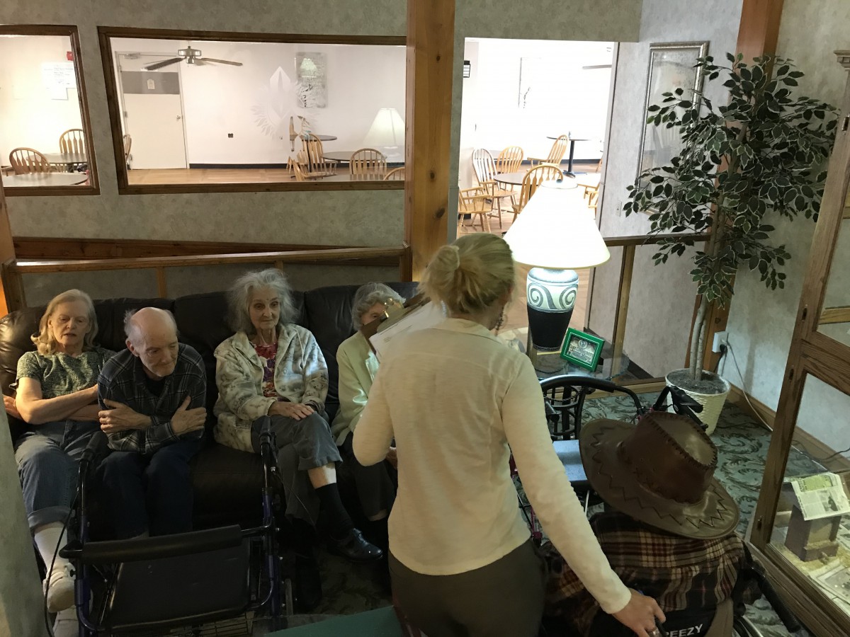 A group of people sitting and conversing in a cozy living room setting.