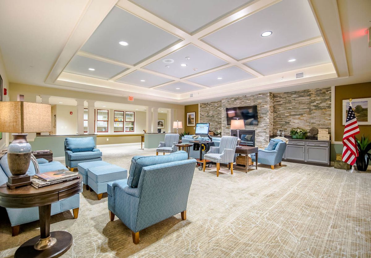 A well-furnished lobby with comfortable chairs and a television.