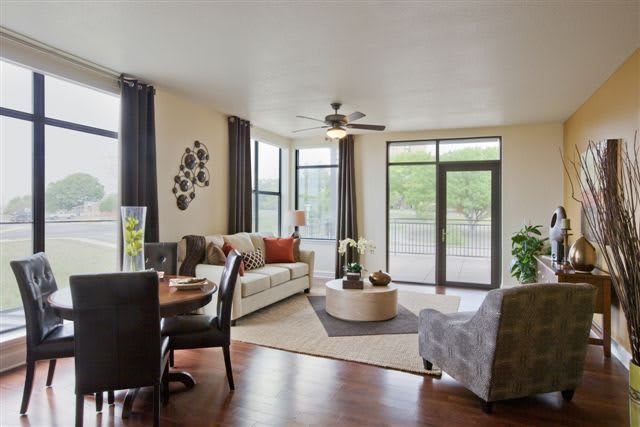 A modern and cozy living room with large windows allowing natural light to brighten the space, featuring stylish furniture in neutral tones.
