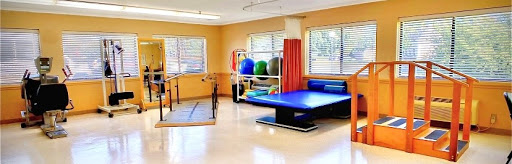 A bright and organized physical therapy room equipped with various exercise tools.