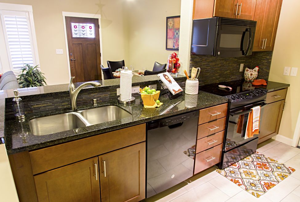 A modern kitchen with a sleek countertop, sink, and various appliances.