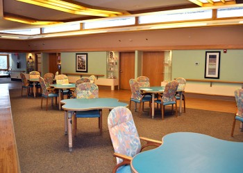A spacious community area with colorful tables and chairs, designed for gatherings or activities.