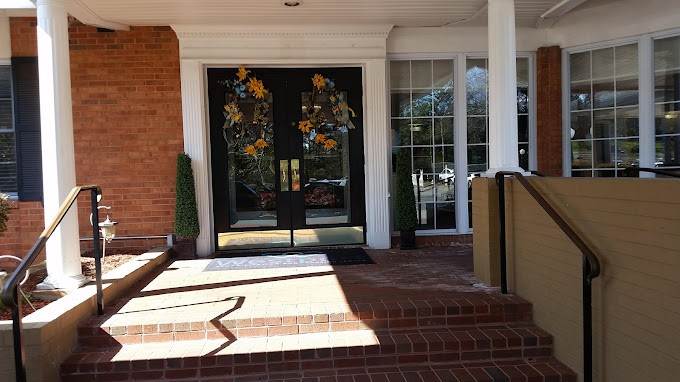 A building entrance featuring double glass doors with decorative designs and a brick pathway.