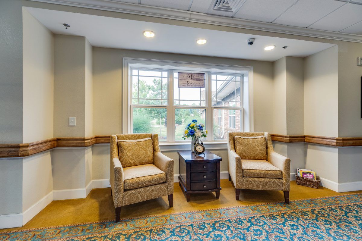 A cozy seating area with two chairs and a table by a large window.