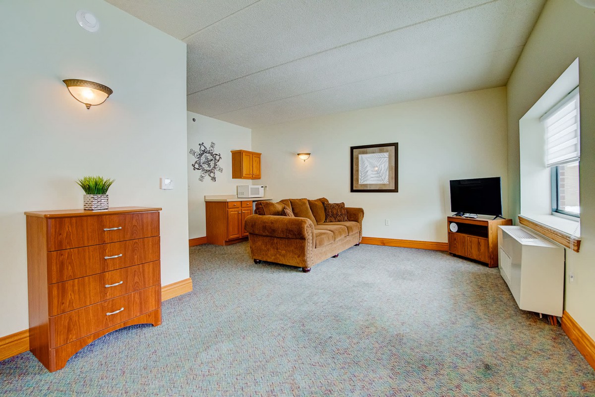 A cozy living room with a sofa, a television, and tasteful decor.