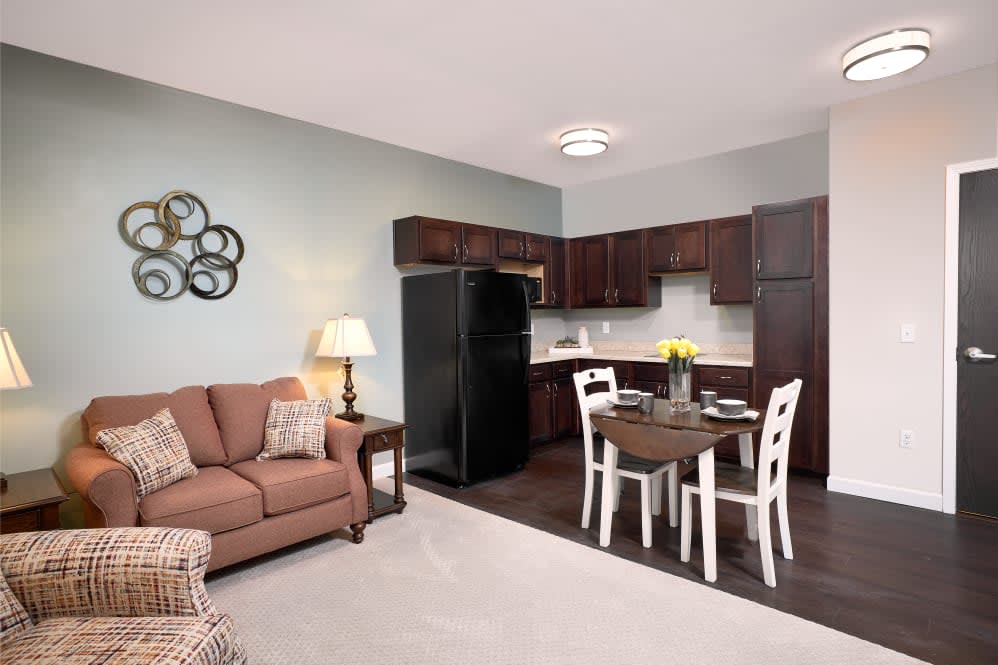 A cozy apartment interior featuring a kitchen, dining area, and living room with modern furniture.