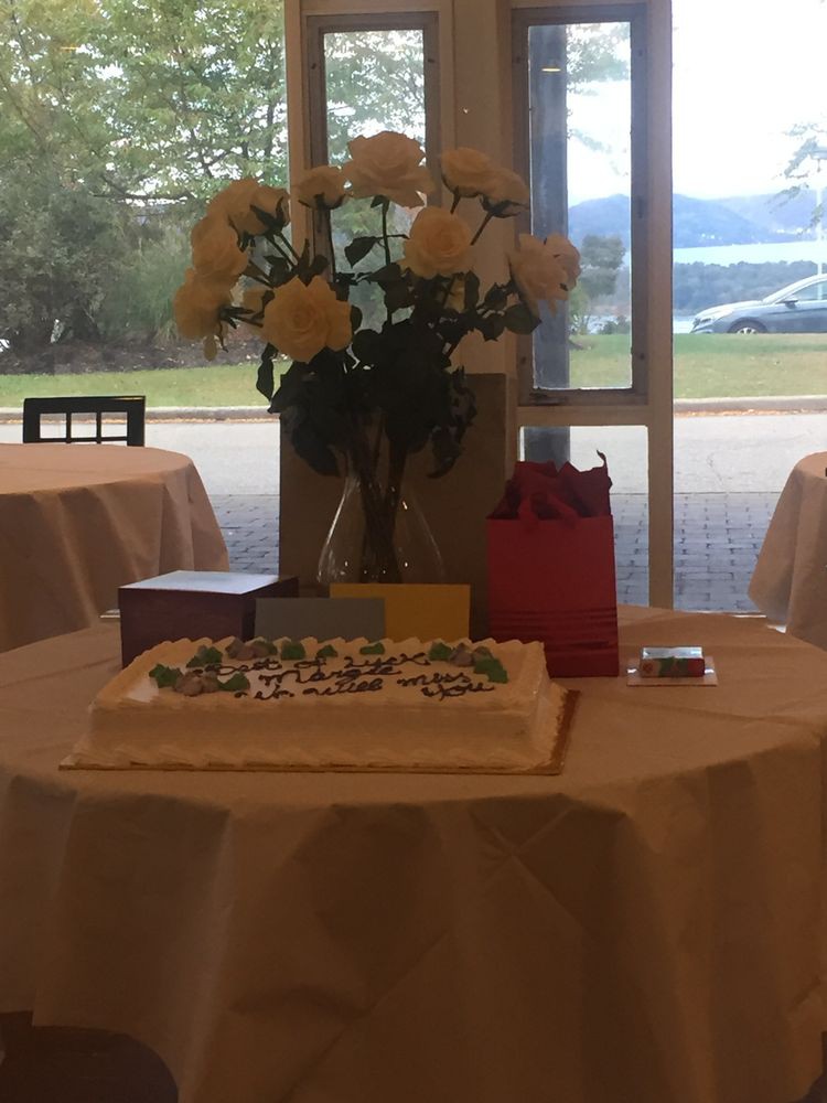 A beautifully decorated table with a cake, flowers, and gift bags, set for a celebration.