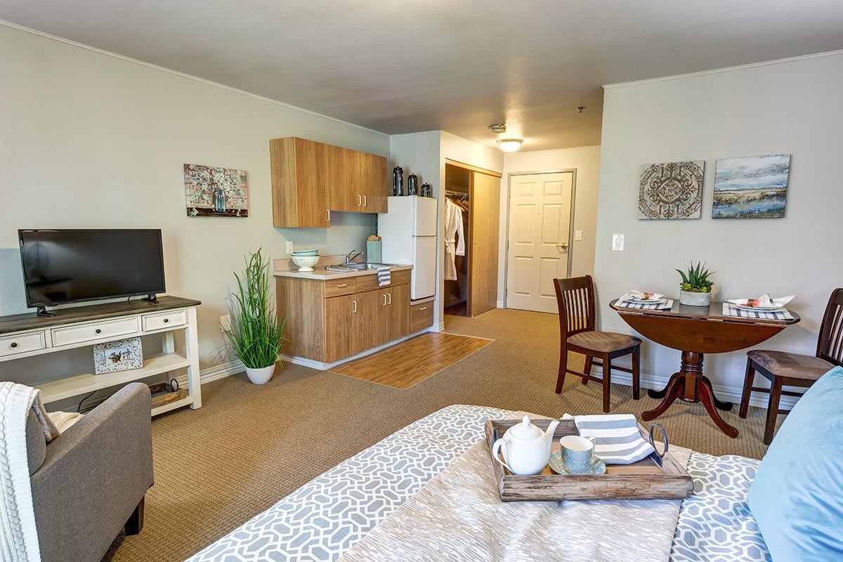 A cozy studio apartment featuring a compact kitchenette, dining area, and comfortable living space.