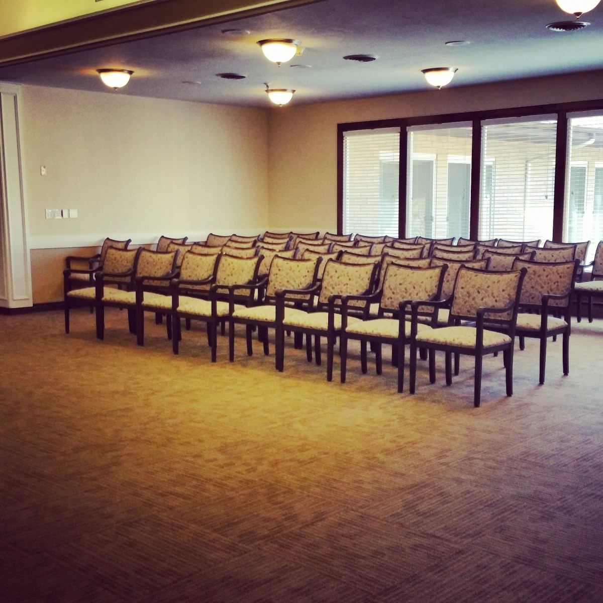 An empty conference room with rows of chairs arranged for a meeting.