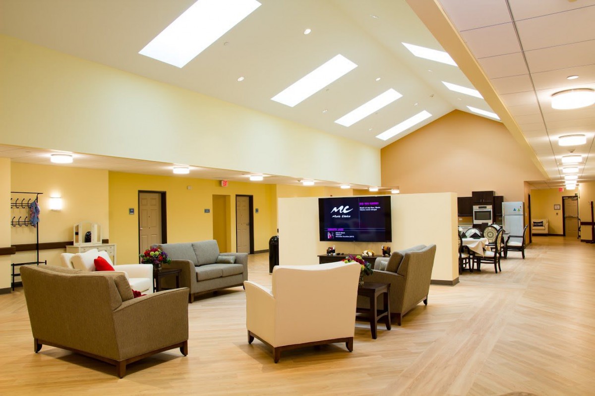 A modern and spacious living room with comfortable sofas and a large TV.