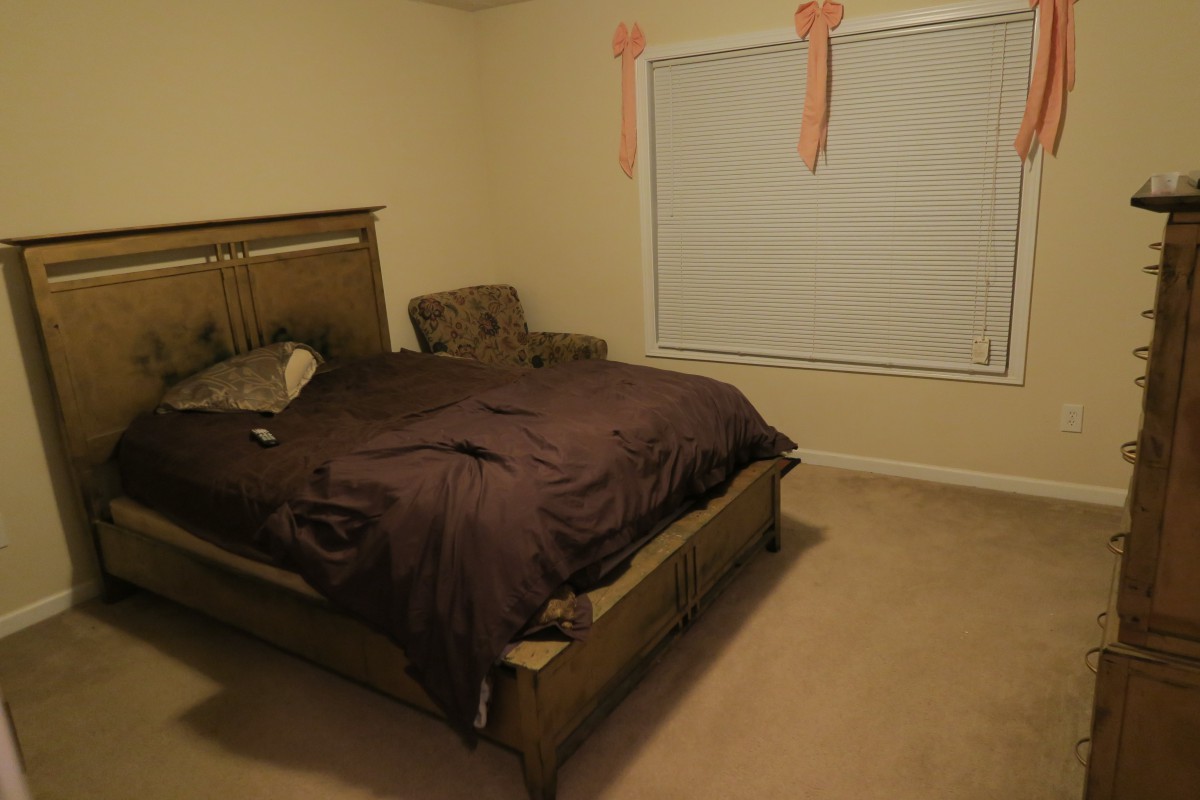 A cozy bedroom with a neatly made bed and simple decor.