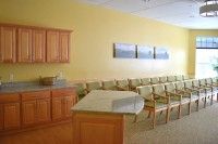 A waiting room with a row of chairs and a countertop.