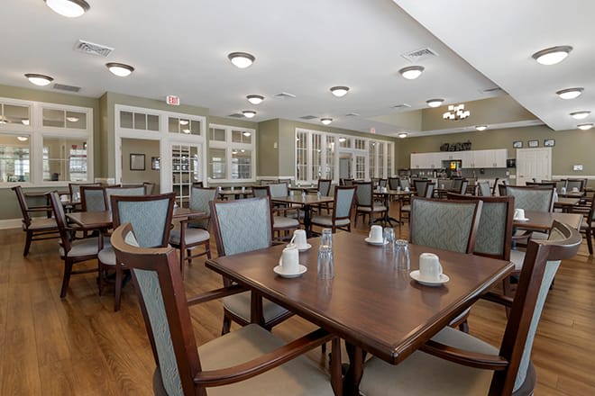 A spacious dining room with neatly arranged tables and chairs, featuring elegant interior design.