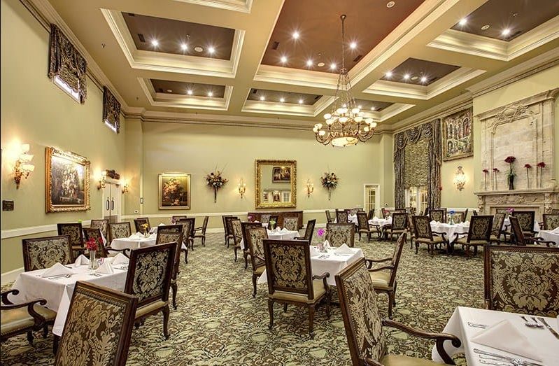 An elegant dining room with chandeliers, classic furniture, and tasteful decorations.