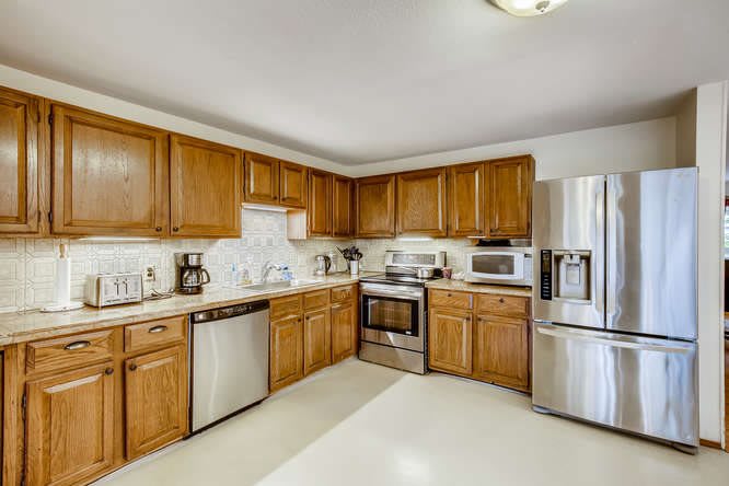 A modern kitchen with wooden cabinets and stainless steel appliances.
