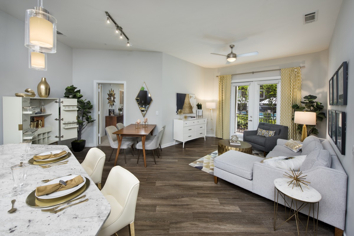A modern living room with a dining area, featuring stylish furniture and ample natural light.