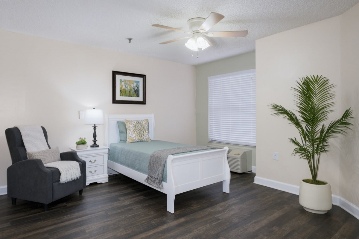 A modern and minimalist bedroom with a single bed, wooden floors, and simple decor.