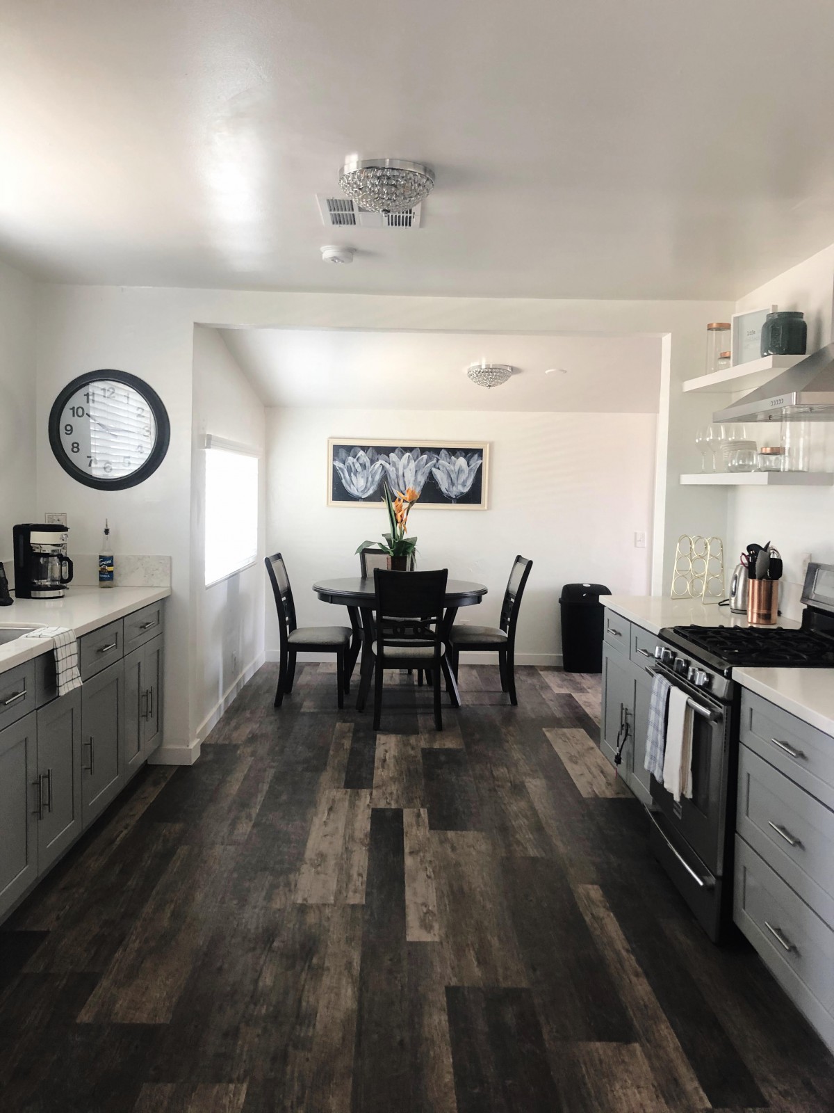A modern kitchen with an adjacent dining area featuring wood flooring and a sleek, open layout.