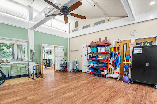 A spacious interior designed for exercise and rehabilitation, featuring fitness equipment and a welcoming atmosphere.