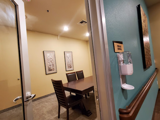 A view into a professional meeting room with a table and chairs, decorated with framed art.