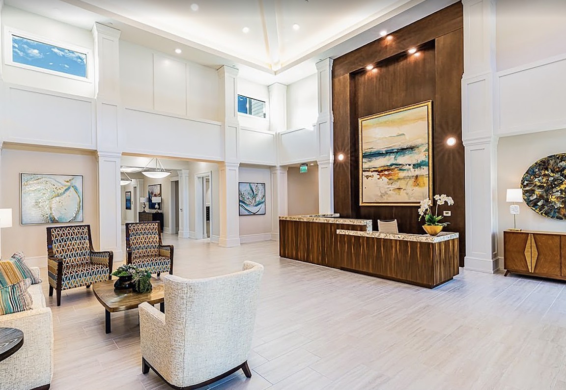 A modern lobby featuring a spacious reception area with elegant furniture and artwork.