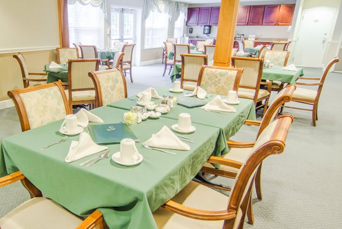 An elegantly set dining room with tables and chairs, ready for guests.