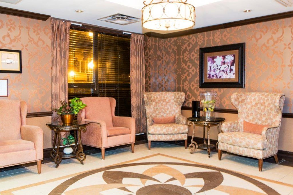 A cozy living room with armchairs, warm lighting, and decorative elements.