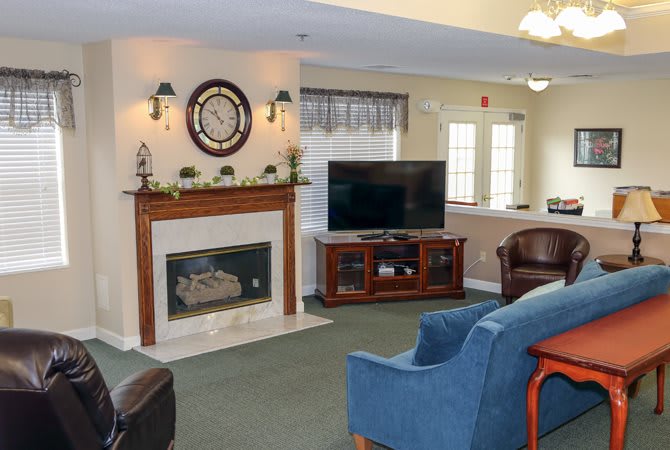 A cozy living room with a fireplace and television, featuring comfortable seating and stylish decor.
