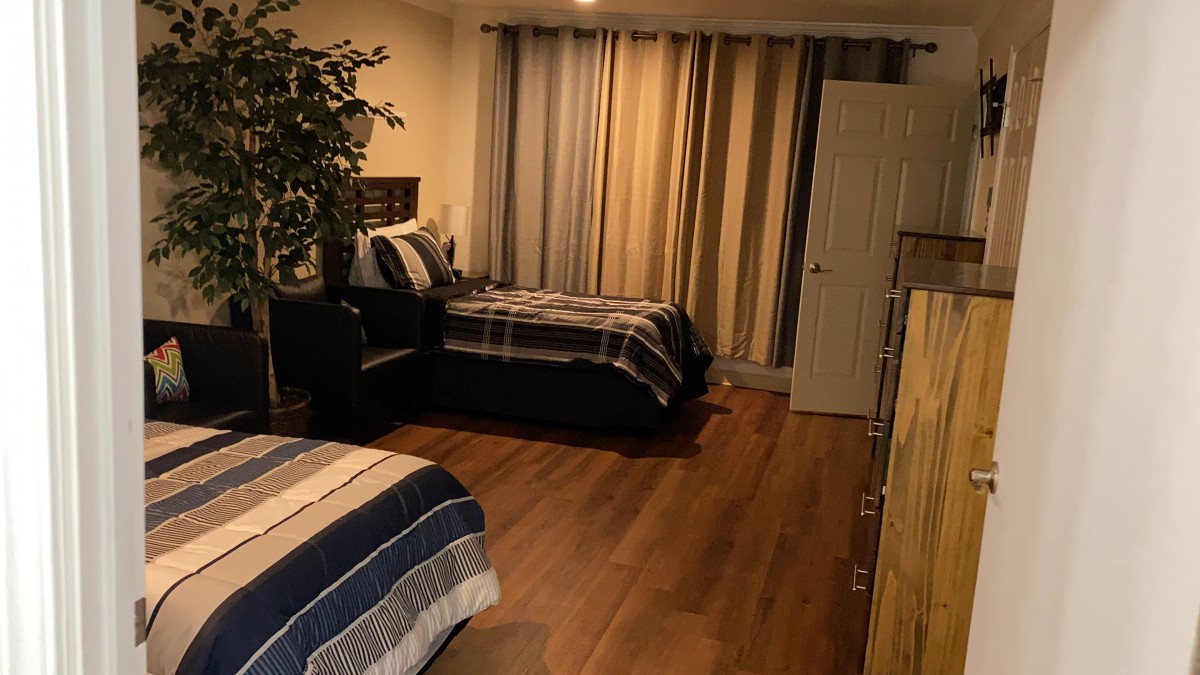 A cozy bedroom with two beds, striped bedding, and soft lighting.