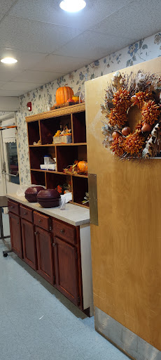 A cozy kitchen corner adorned with autumn decorations, featuring a stylish wreath and decorative pumpkins.