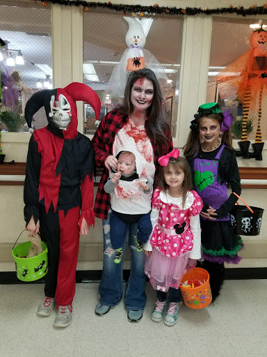 A group of friends and family dressed in creative Halloween costumes, ready for a night of trick-or-treating.